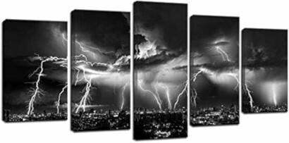 Panoramic black and white image of a lightning storm over a city skyline.