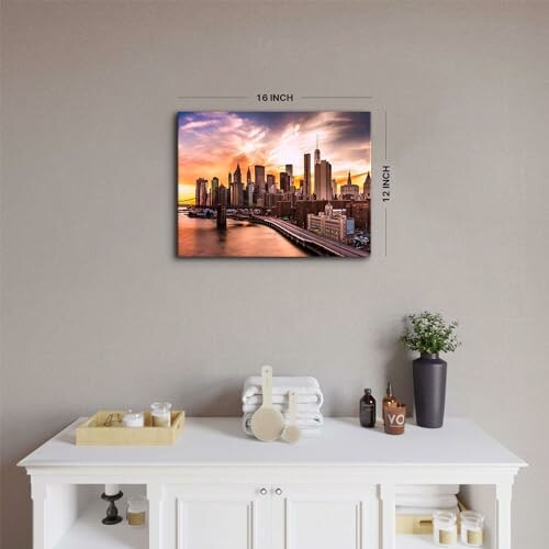 Cityscape wall art above a white table with decor items.