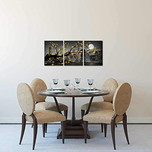 Dining room with round table and wall art of tree branches.