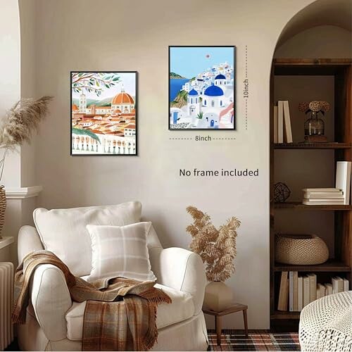 Cozy living room with two framed artworks on the wall, beige armchair, and bookshelf. Add a touch of elegance to your living room with a stunning cityscape artwork.