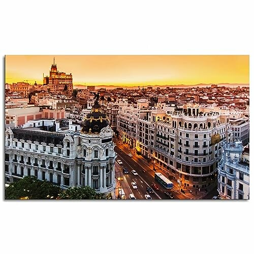 Aerial view of Madrid cityscape at sunset with historic buildings and busy streets.