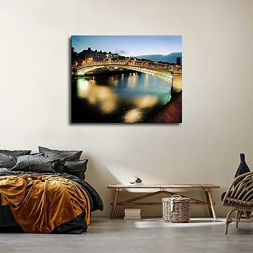 Modern bedroom with a canvas of a lit bridge over water on the wall.