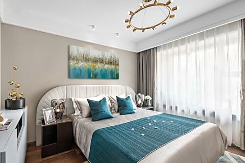 Modern bedroom with teal accents and abstract artwork.