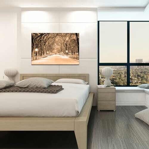 Modern bedroom with large bed, artwork, and city view.