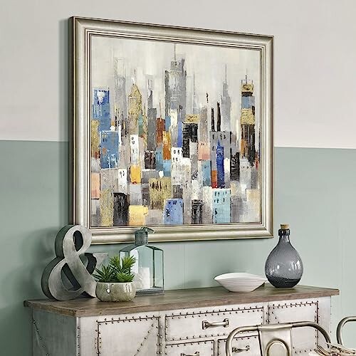 Framed cityscape painting on a wall above a decorative console table.