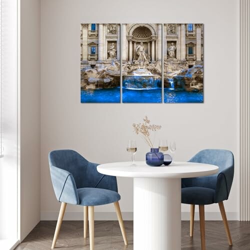 Dining room with round table, blue chairs, and wall art