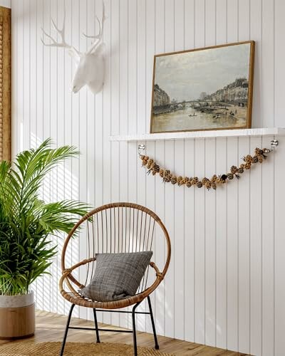 Scandinavian-style room with wicker chair, plant, and wall art.