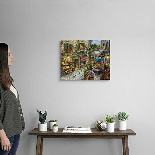 Woman looking at a colorful painting on a wall above a shelf with plants and books.